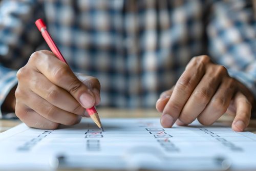 Image of a student analyzing test paper: Student analyzing mock test performance for competitive exams